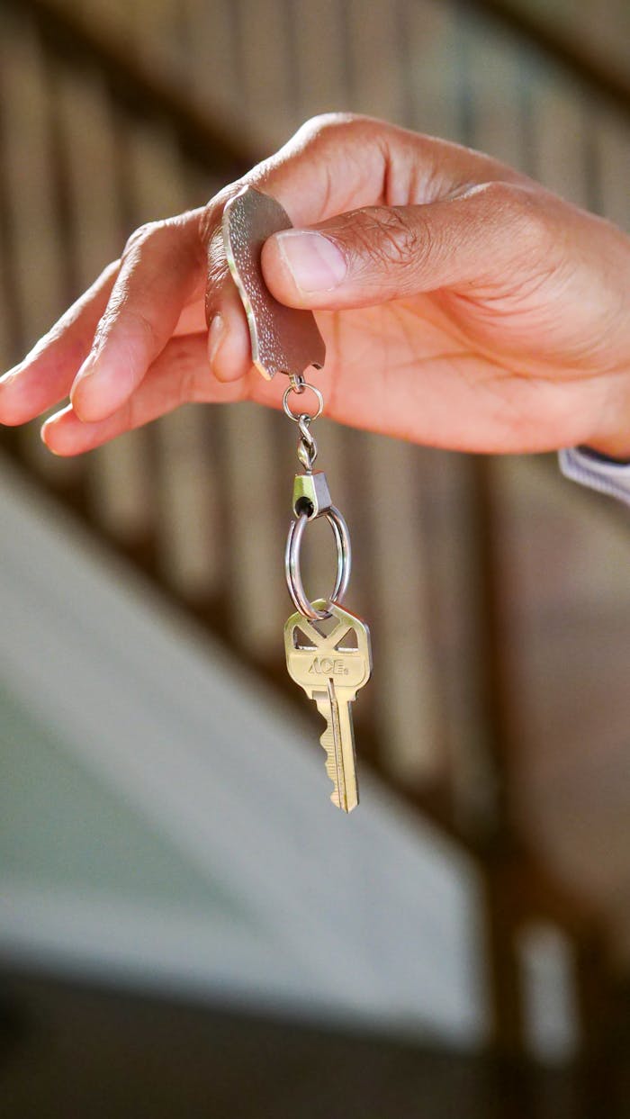 team-01 Close-up of a hand holding a key, symbolizing new homeownership or rental.